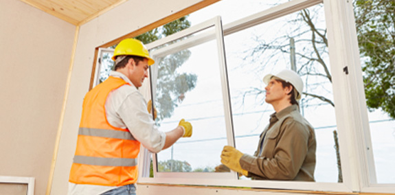 Contractors working together to perform window installation in Peoria IL