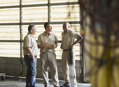 Group of workers in a manufacturing facility standing in front of Commercial Doors in Peoria IL