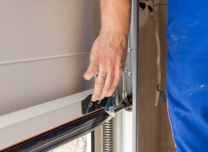 A technician lifting a garage door during Garage Door Service in Bloomington IL