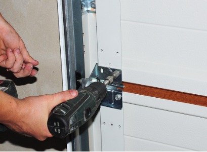 Technician screwing hinges as part of Garage Door Repair in Canton IL