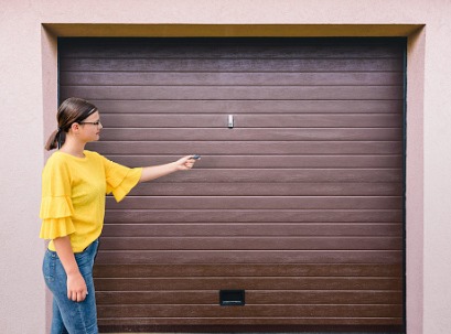 Woman opening a new garage door installed by the one of the go-to Garage Door Companies for Pekin IL 