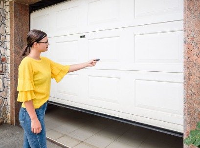 Woman opening garage door after successful Garage Door Replacement in Bloomington IL 