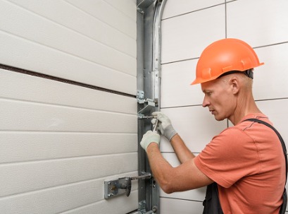 A man tightening hinges during Garage Door Repair in Dunlap IL 